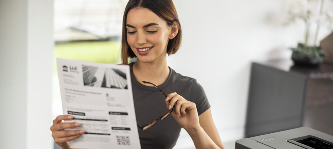 A woman in the office reading a printed article